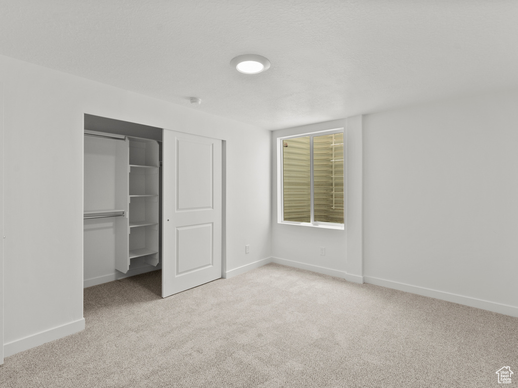 Unfurnished bedroom featuring carpet and a closet