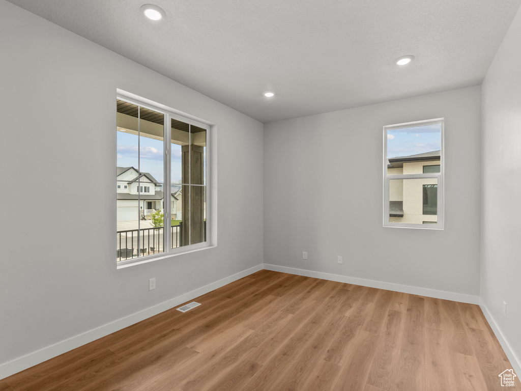 Spare room featuring light wood finished floors and recessed lighting