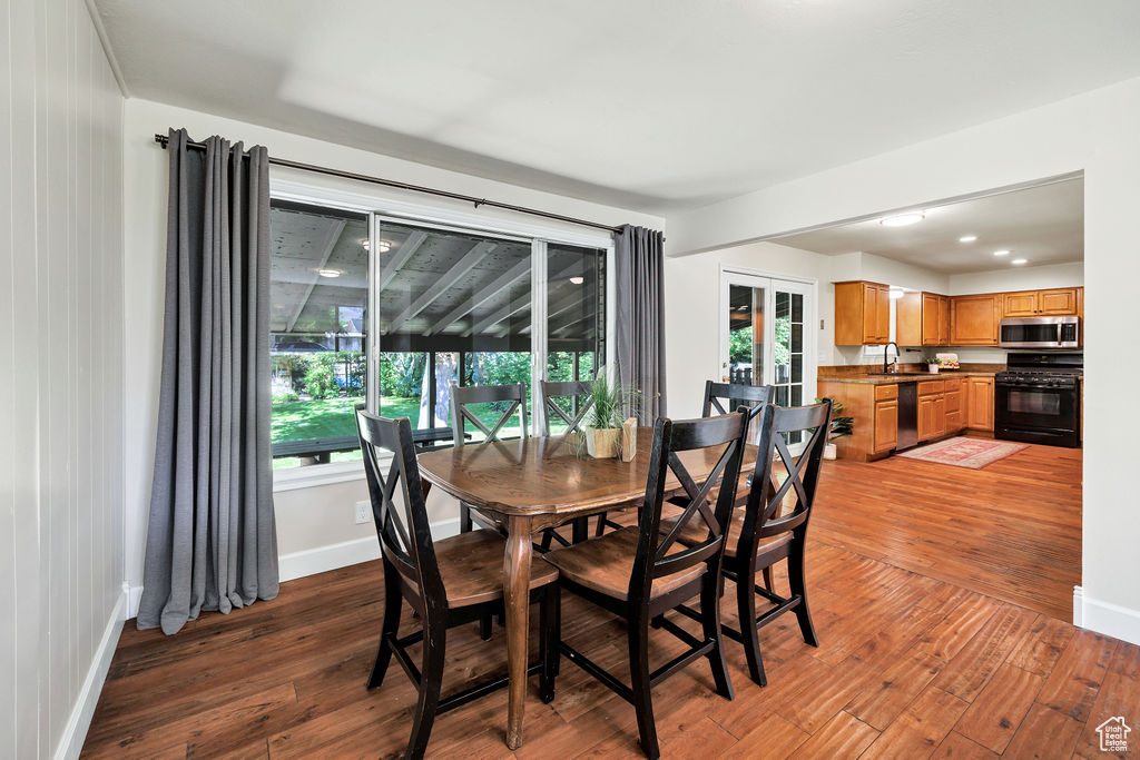 Dining room featuring wood-type flooring, baseboards, and plenty of natural light