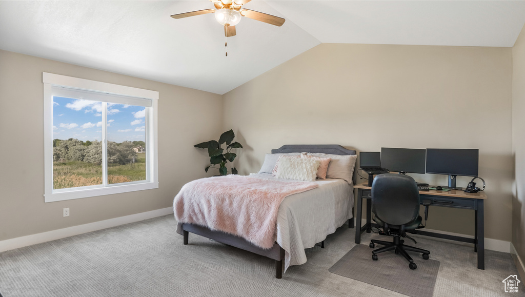 Bedroom featuring lofted ceiling, baseboards, light carpet, ceiling fan, and a desk
