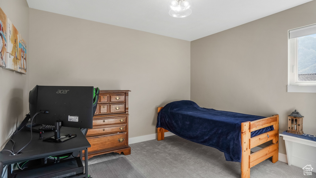 Bedroom with carpet flooring, baseboards, and an office area