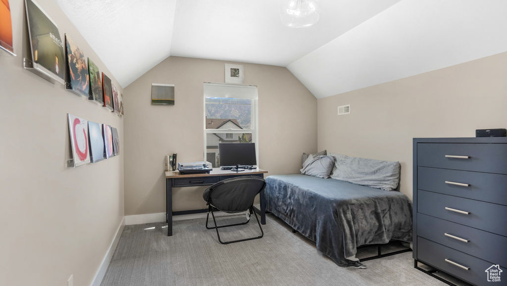 Bedroom featuring vaulted ceiling, light colored carpet, and baseboards