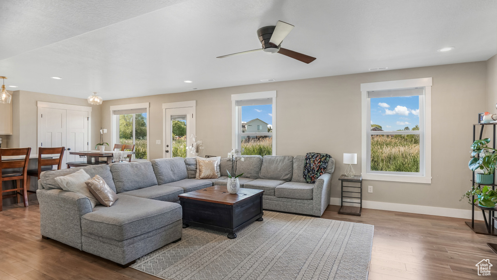 Living area with wood finished floors, recessed lighting, a ceiling fan, and baseboards
