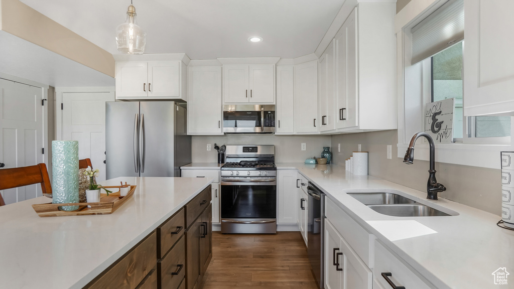 Kitchen featuring stainless steel appliances, a sink, recessed lighting, light countertops, and white cabinetry