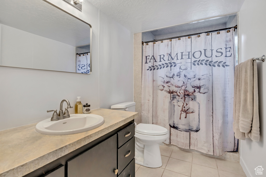 Full bath featuring tile patterned flooring, vanity, and toilet