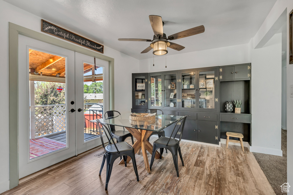 Dining room with french doors, ceiling fan, and light wood-style floors
