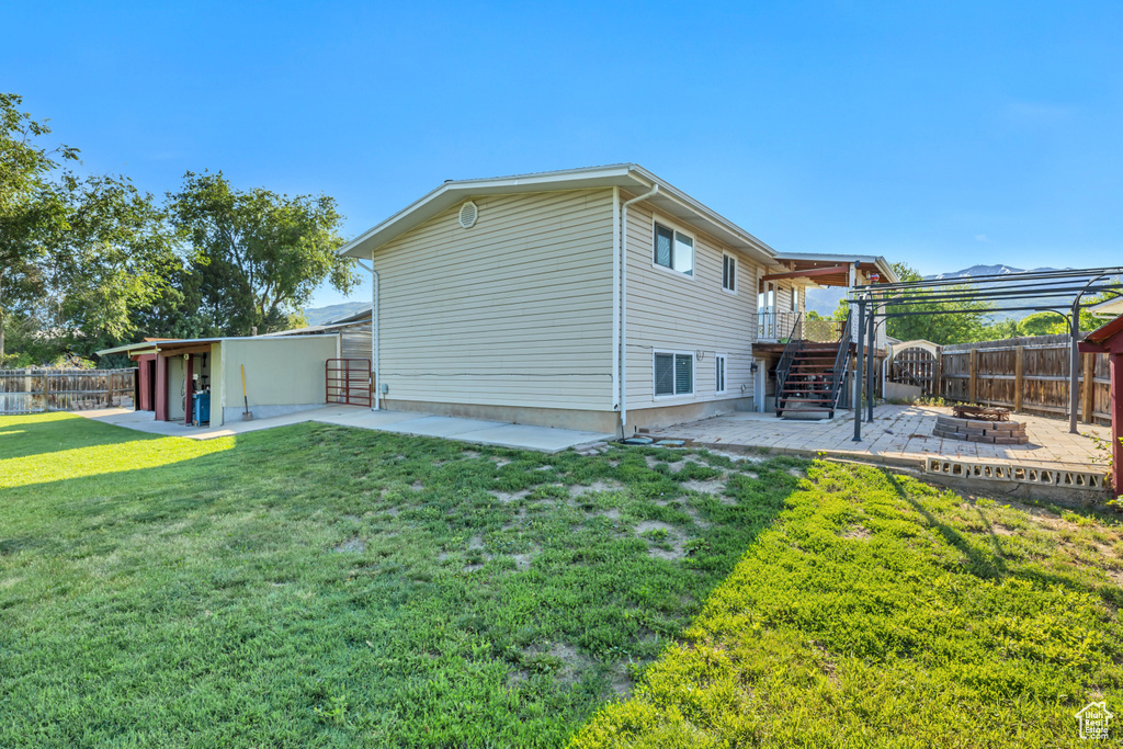 View of side of home with a patio area, stairway, and a fire pit