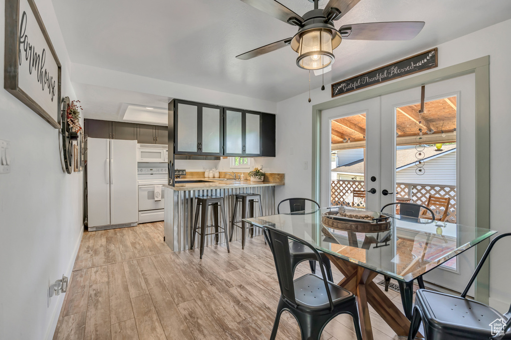 Dining area featuring ceiling fan, french doors, light wood-style floors, and baseboards