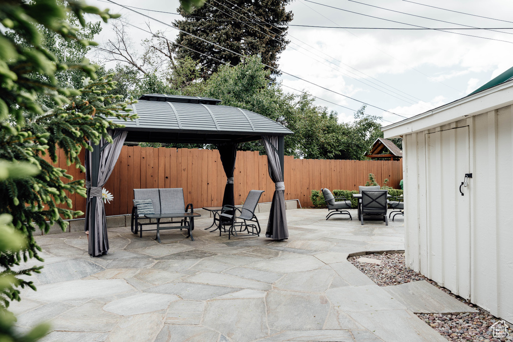 Fenced backyard featuring a gazebo, a patio, and outdoor lounge area