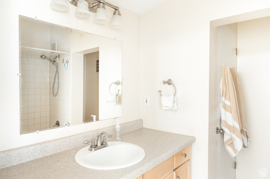Bathroom featuring vanity and tiled shower