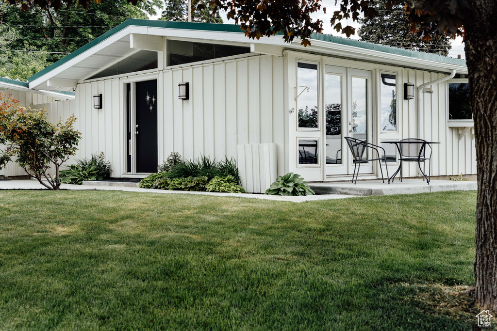 View of front of home featuring board and batten siding and a front yard