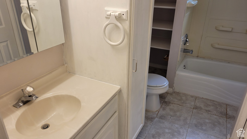 Full bathroom with toilet, vanity, tile patterned floors, and shower / bath combination