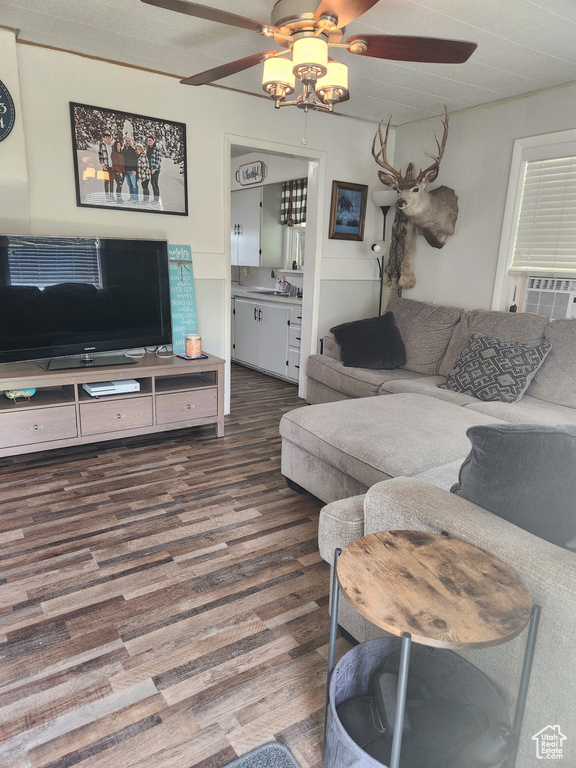 Living room featuring ceiling fan, wood finished floors, and cooling unit