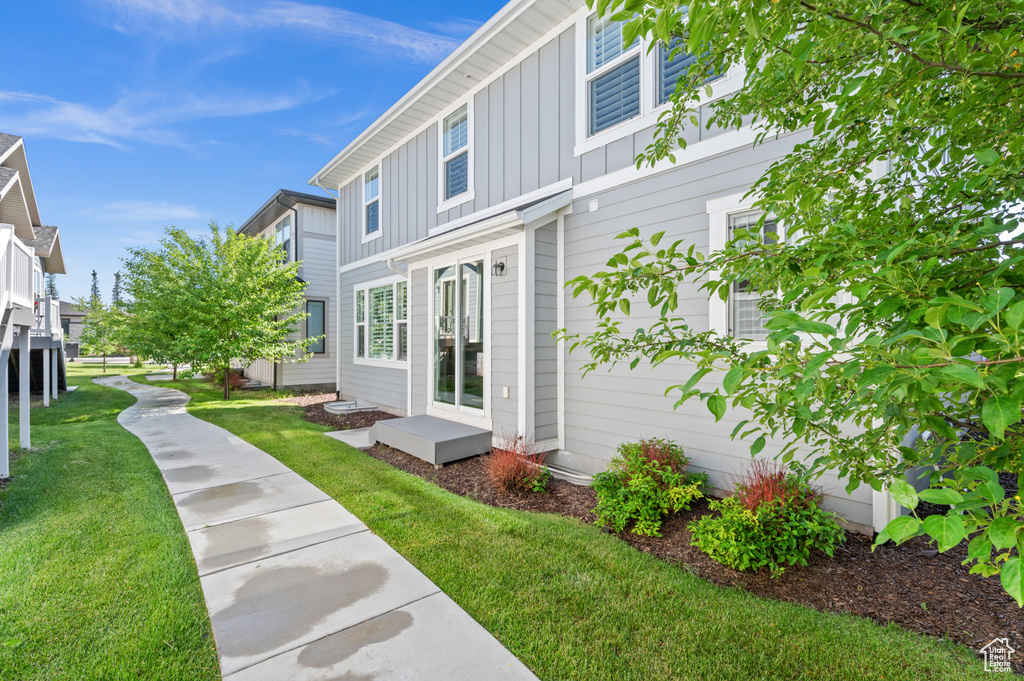 View of property exterior featuring board and batten siding and a lawn