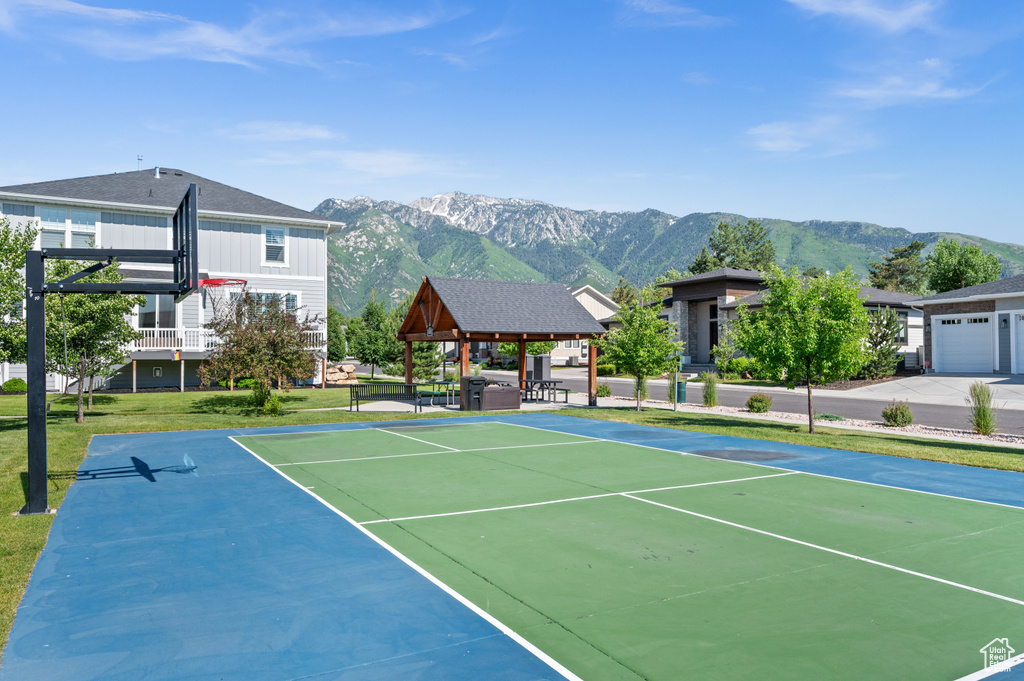 View of tennis court with a gazebo, a mountain view, a yard, and community basketball court