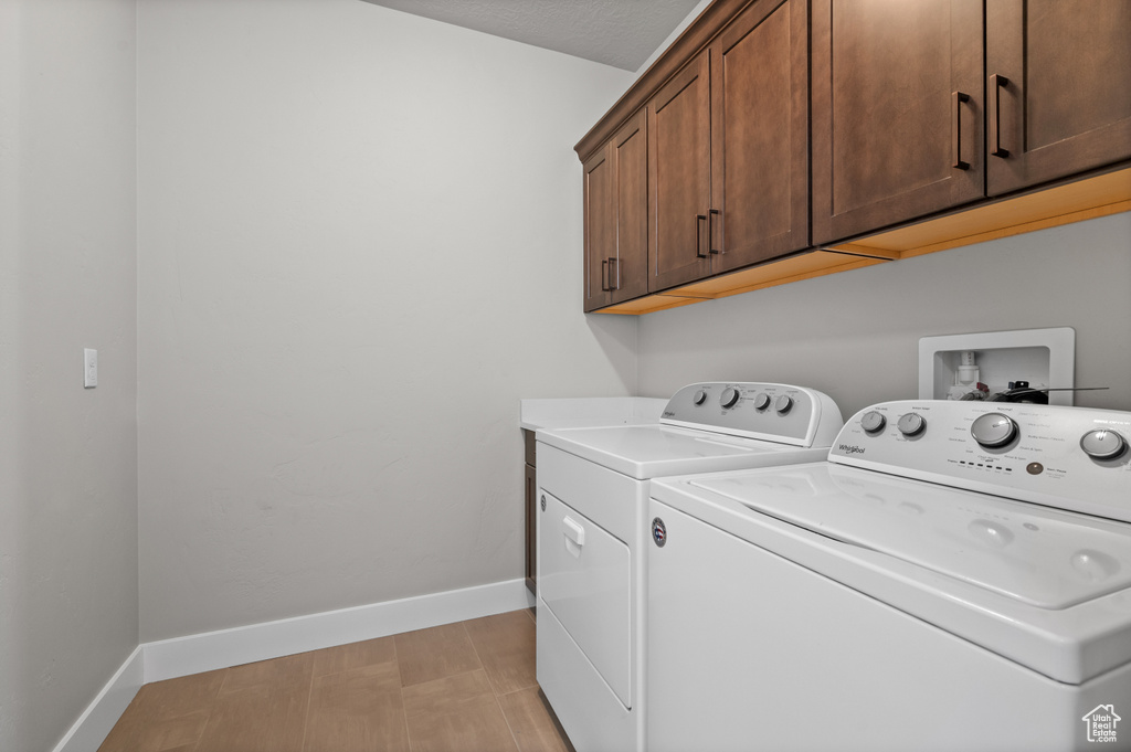 Laundry room featuring cabinet space, washer and clothes dryer, and baseboards