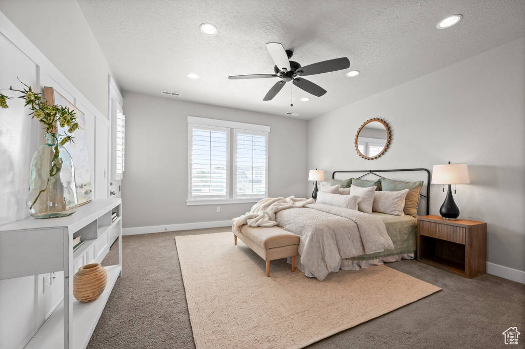 Carpeted bedroom featuring a textured ceiling, recessed lighting, baseboards, and a ceiling fan