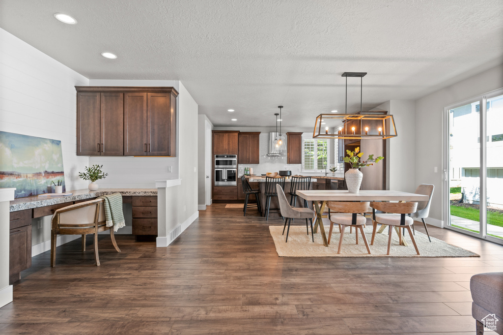 Dining area featuring a textured ceiling, dark wood-type flooring, recessed lighting, baseboards, and a desk