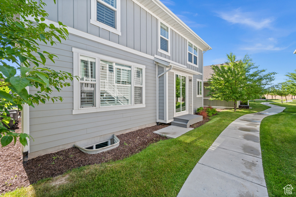 View of side of property with board and batten siding and a yard