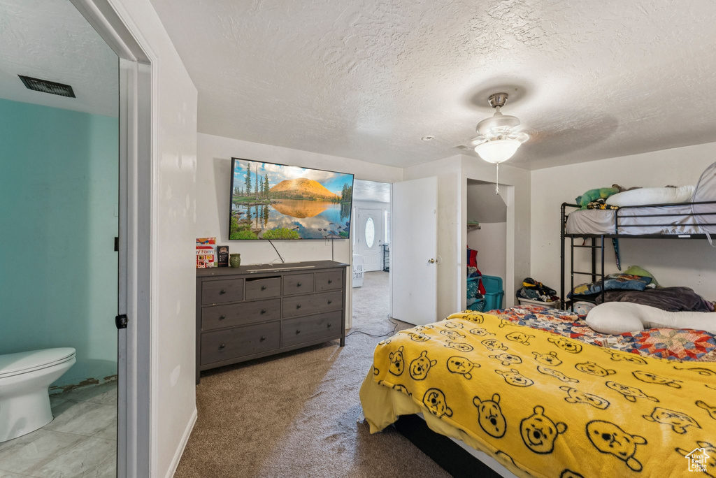 Bedroom featuring a textured ceiling, carpet flooring, and baseboards