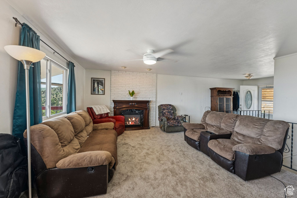 Living room with carpet floors, a ceiling fan, and a brick fireplace