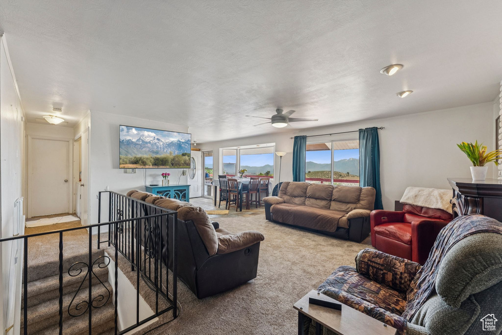 Carpeted living area with a ceiling fan