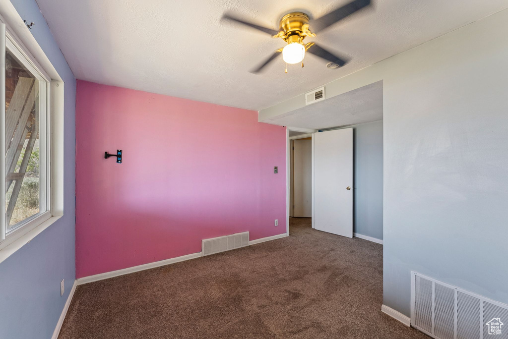 Unfurnished room featuring carpet floors, a ceiling fan, and baseboards