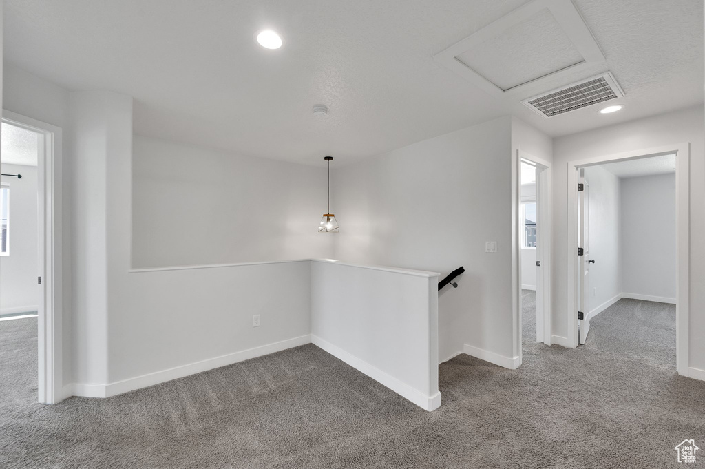Carpeted spare room with baseboards, recessed lighting, and attic access