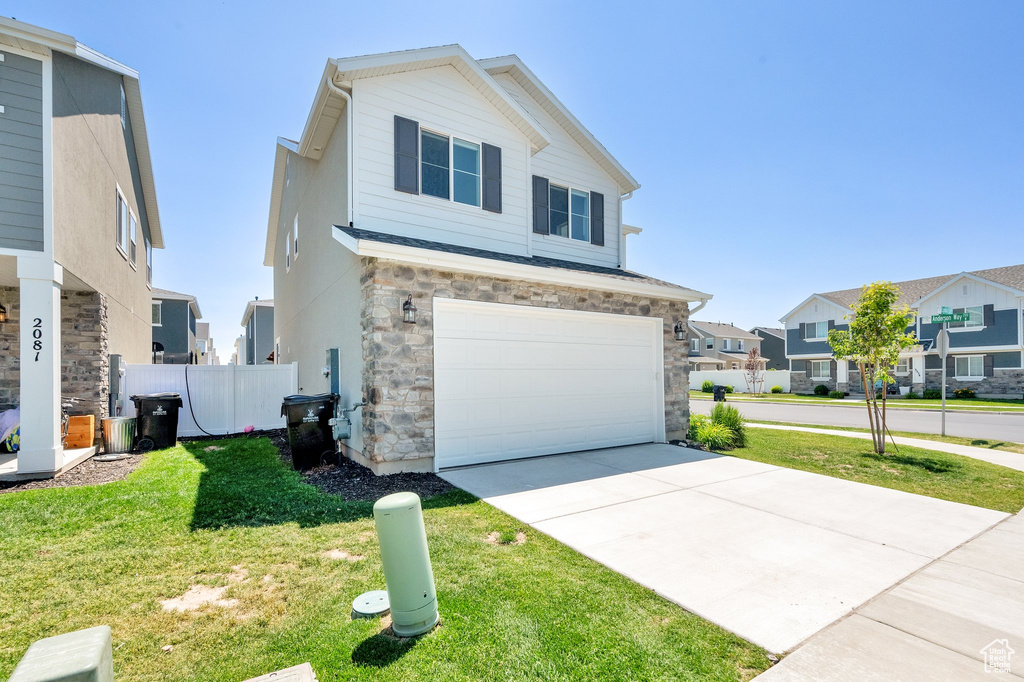 View of front of house featuring a residential view, stone siding, an attached garage, and concrete driveway
