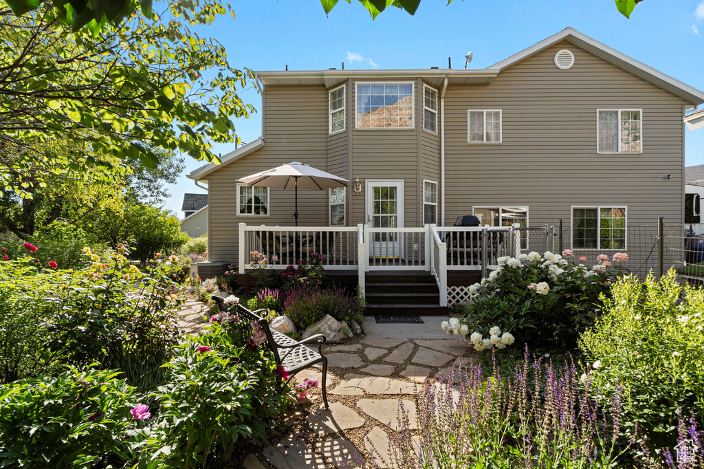 Rear view of house with a deck and a patio