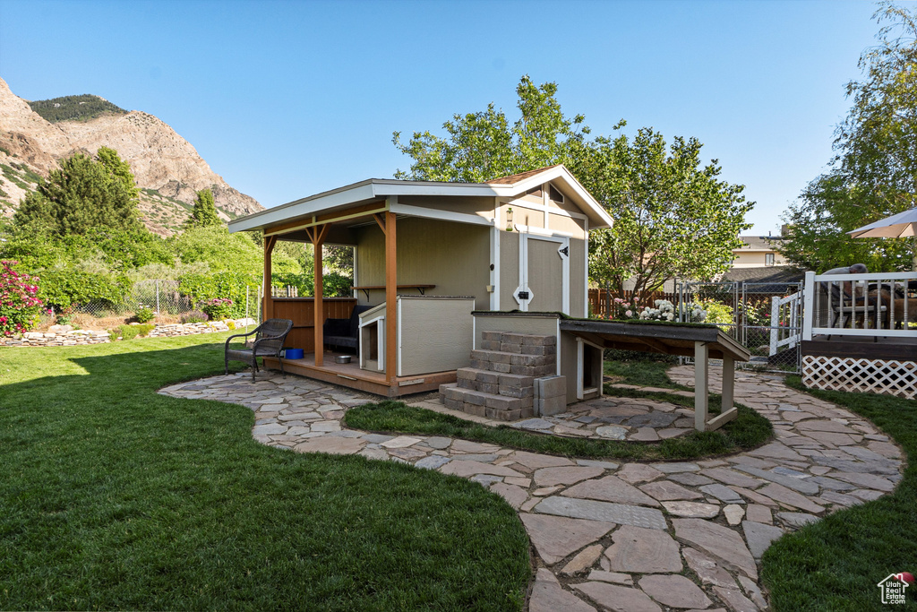 Back of house with an outbuilding and a deck with mountain view