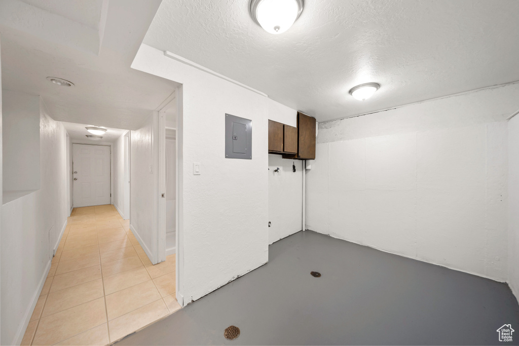 Below grade area featuring electric panel and a textured ceiling