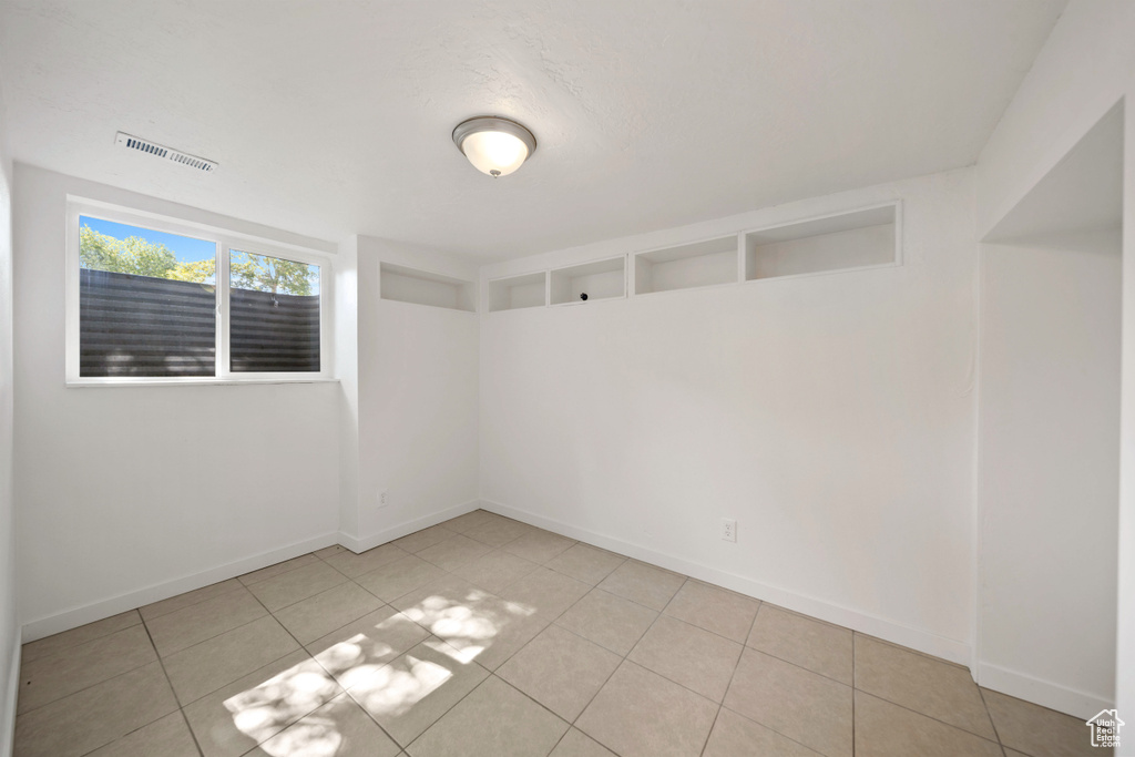 Spare room with baseboards and tile patterned flooring