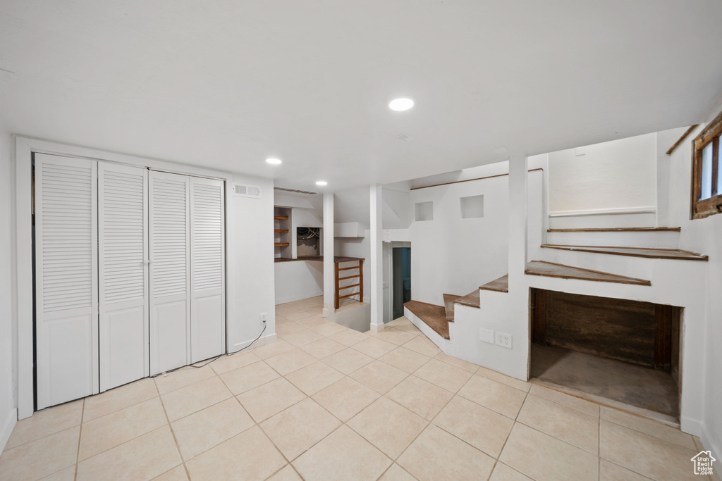 Unfurnished living room featuring stairs, recessed lighting, and tile patterned flooring