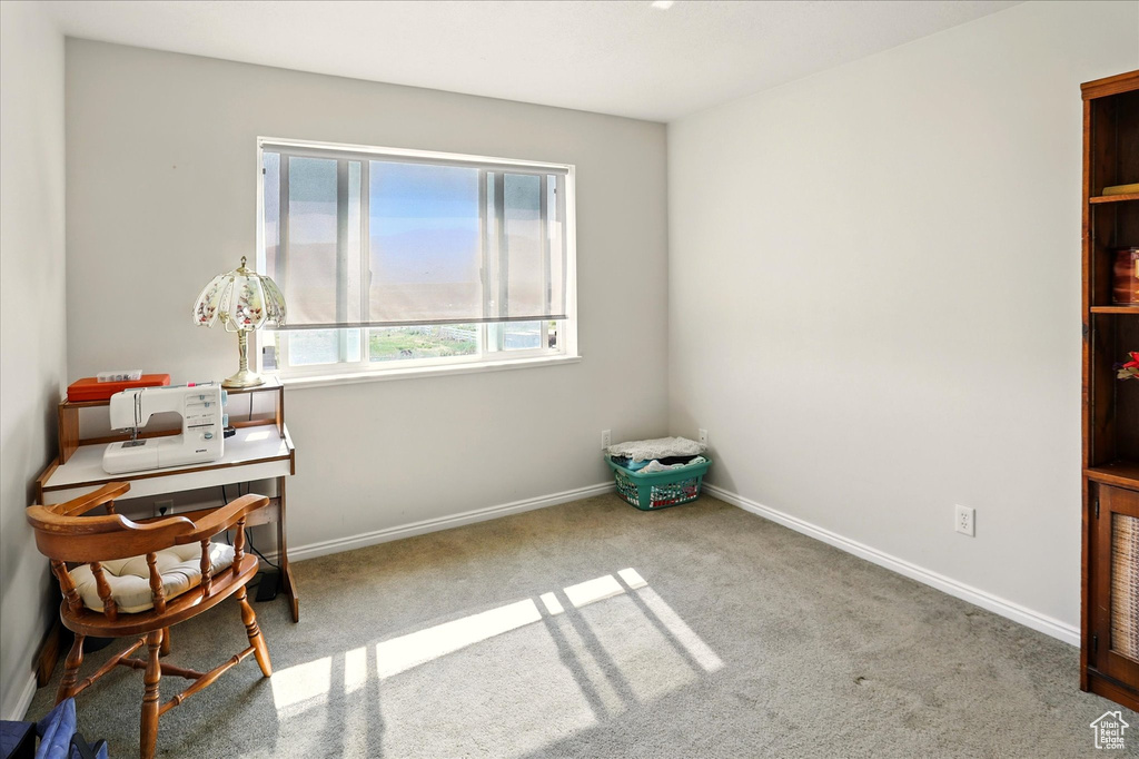Sitting room featuring carpet, a desk, and baseboards