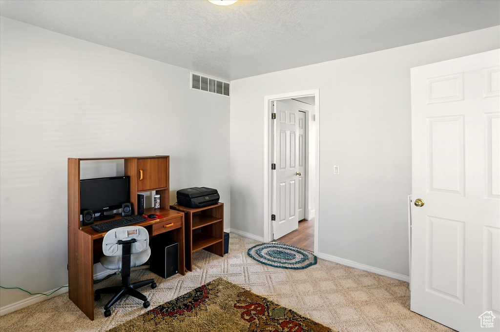 Office area featuring light carpet and baseboards