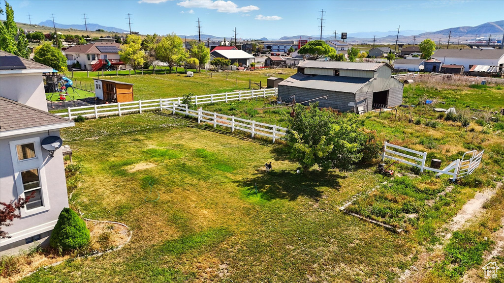 View of yard with an outdoor structure, a mountain view, a residential view, and an outbuilding
