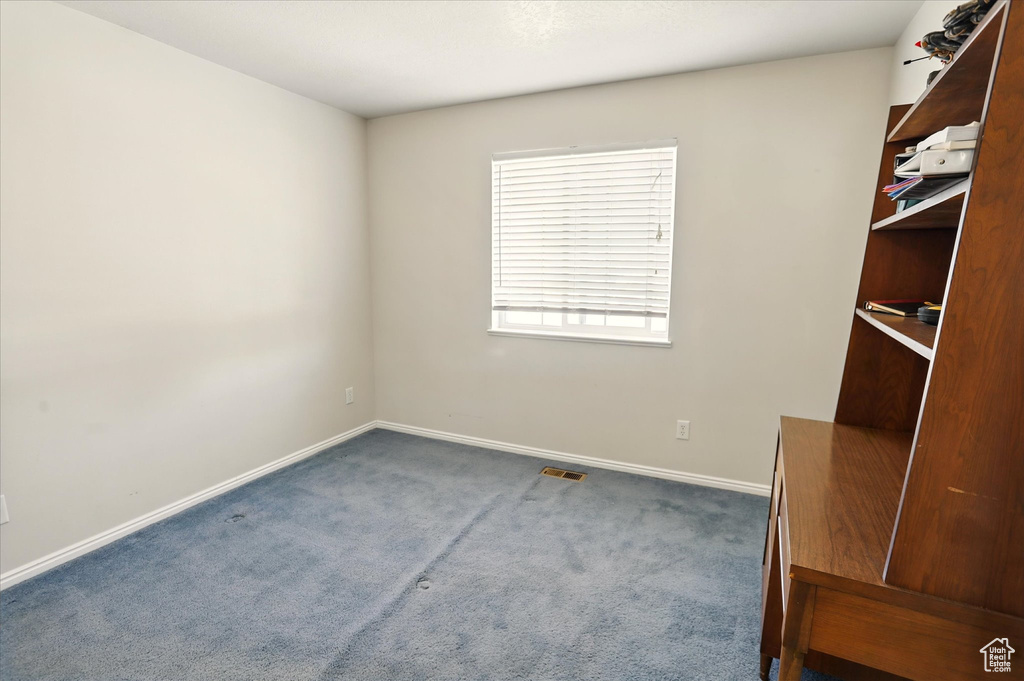 Empty room featuring carpet flooring and baseboards