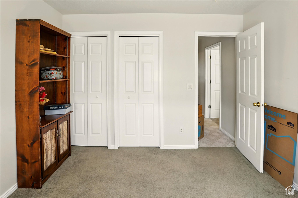Bedroom featuring carpet floors, multiple closets, and baseboards