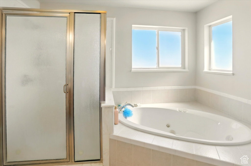 Full bath featuring a shower stall and a whirlpool tub