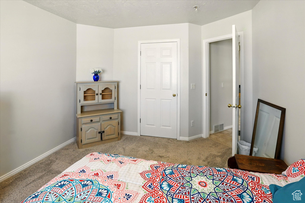 Bedroom with light carpet and baseboards