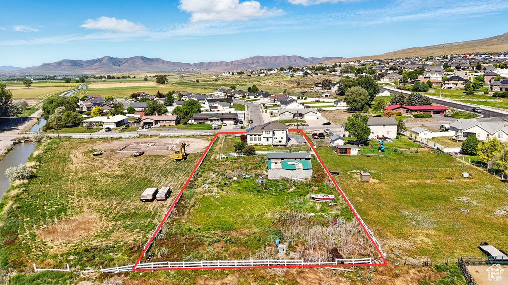 Aerial perspective of suburban area with property boundaries highlighted and a mountainous background