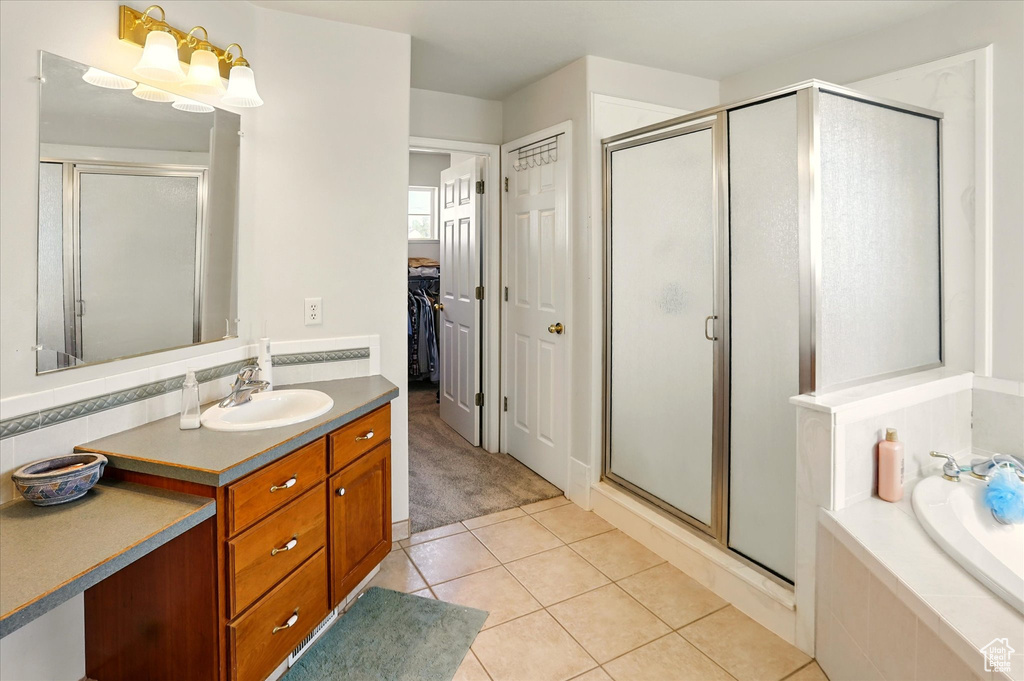 Full bathroom featuring vanity, a stall shower, tile patterned floors, and a bath