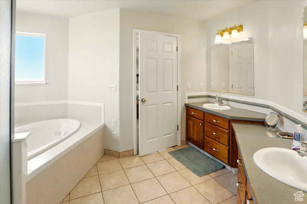 Full bathroom featuring vanity, a whirlpool tub, and tile patterned flooring