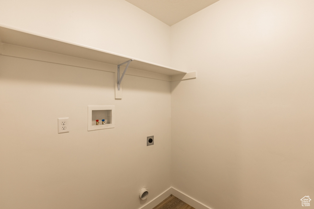 Clothes washing area featuring wood-type flooring, electric dryer hookup, and washer hookup