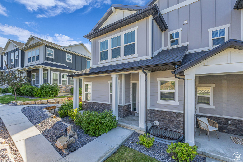 Craftsman house featuring board and batten siding, stone siding, and a porch