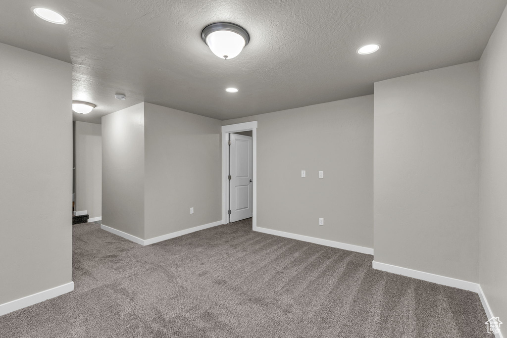 Spare room featuring carpet, baseboards, a textured ceiling, and recessed lighting