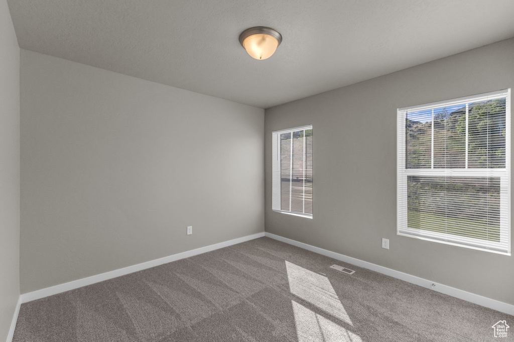 Empty room with carpet floors and baseboards