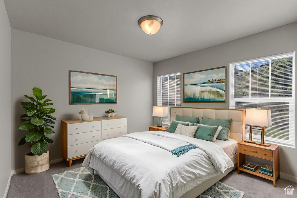 Bedroom with light colored carpet and baseboards