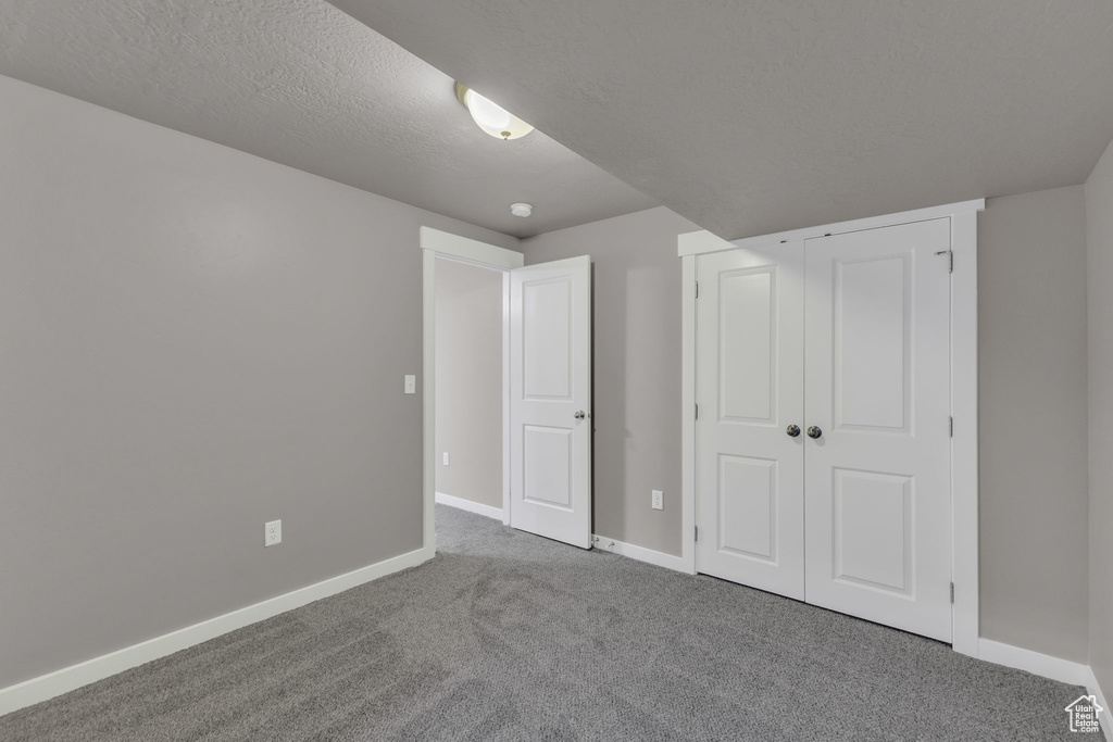 Unfurnished bedroom featuring carpet, baseboards, and a closet